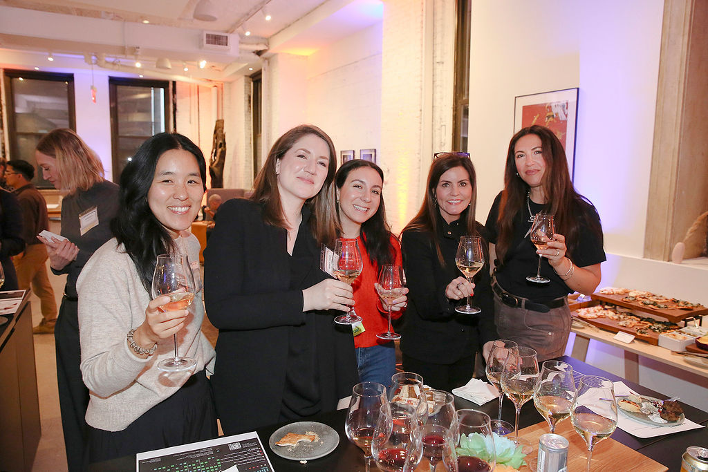 Five FFiH members raise their wine glasses at an evening networking reception