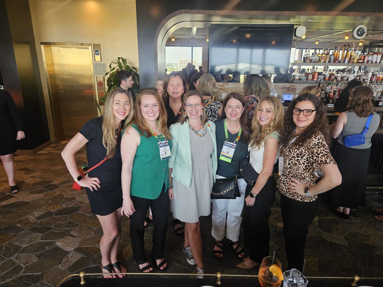 A group of FFiH members gathered at the bar during a HITEC reception